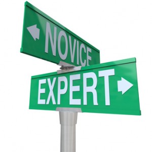 Expert Vs Novice words on green two way road signs to illustrate the power of skills, expertise and experience to get a job done or task completed